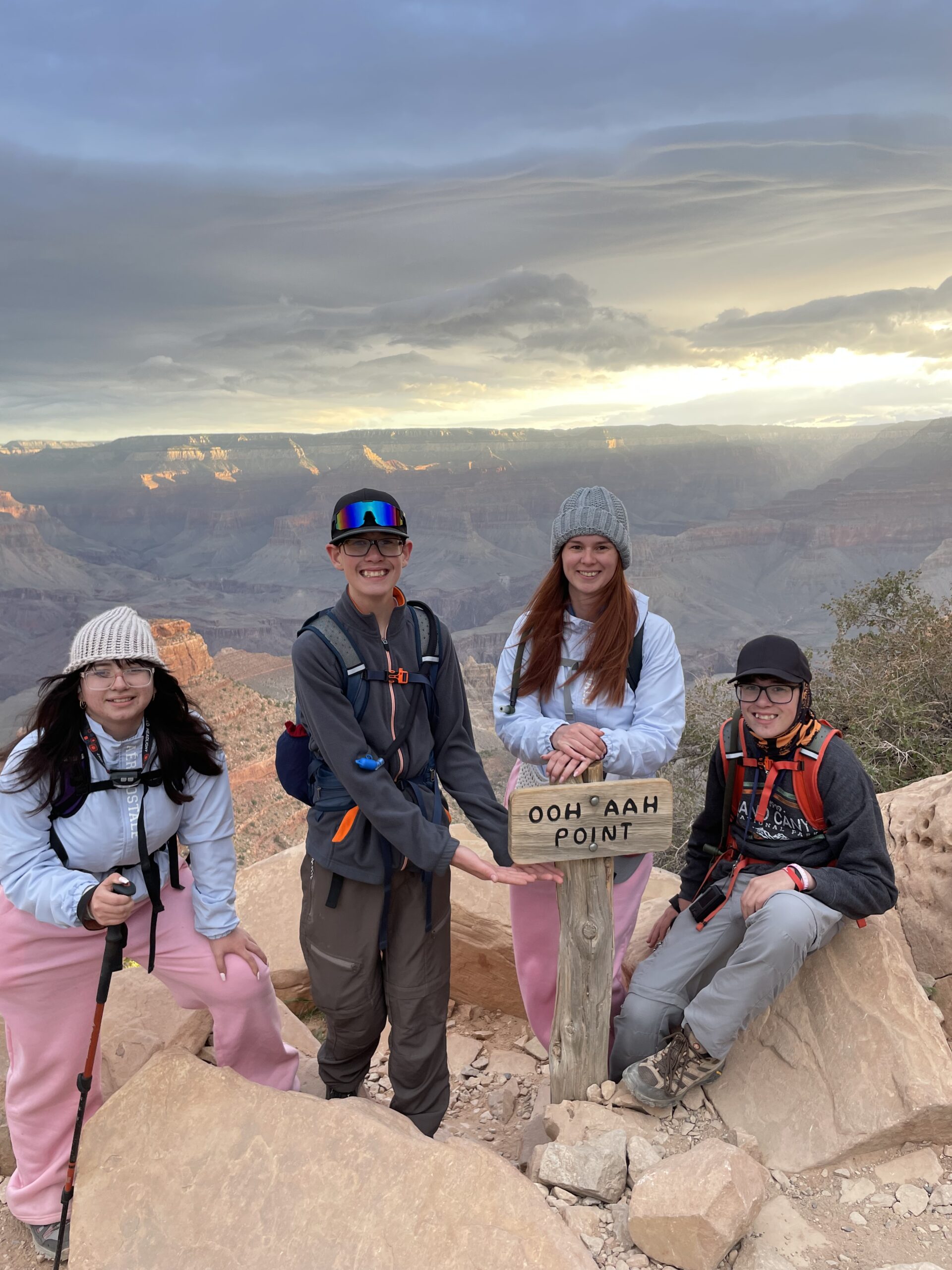 a photo of Tiffany and her 3 kids at a sign labeled OOH AAH POINT in the Grand Canyon